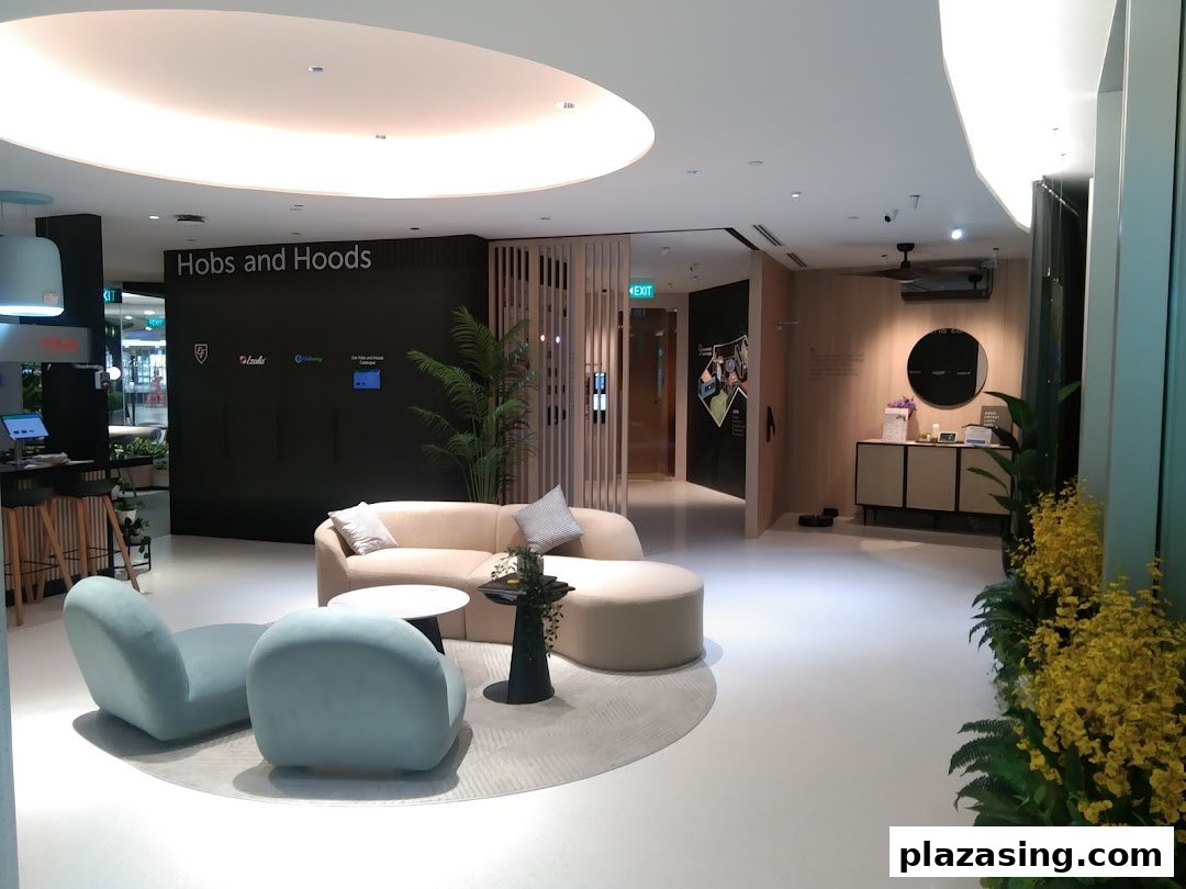 A modern showroom interior featuring comfortable seating, a counter, and a 'Hobs and Hoods' display.