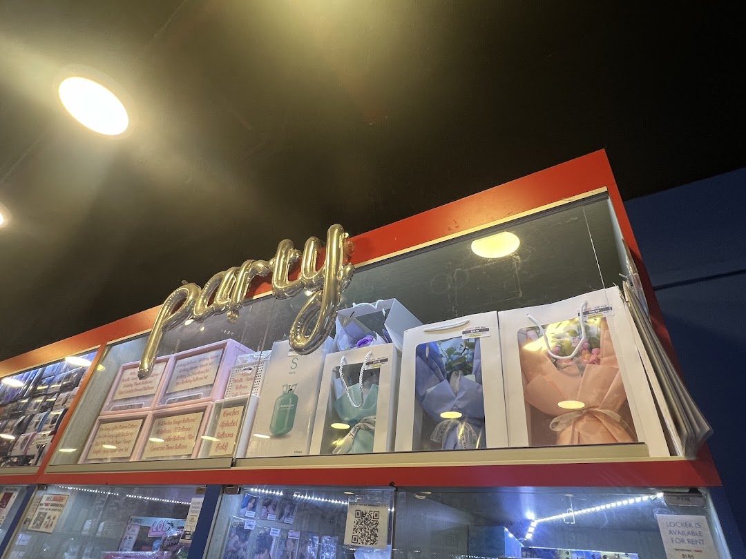 An interior shot of LittlePartyStuffs, showcasing party supplies, balloons, and gift items on a brightly lit display.