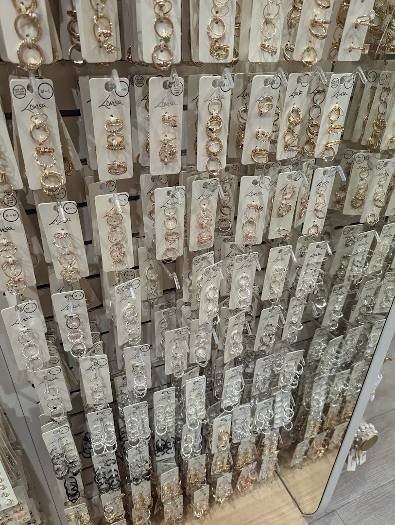 A wall display showcasing a wide variety of Lovisa rings in gold, silver, and rose gold tones.