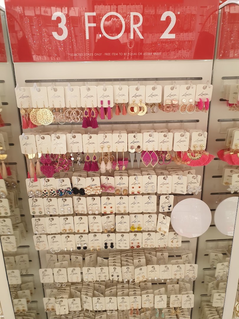A display stand showcasing a wide variety of Lovisa earrings with a prominent '3 FOR 2' promotion sign.