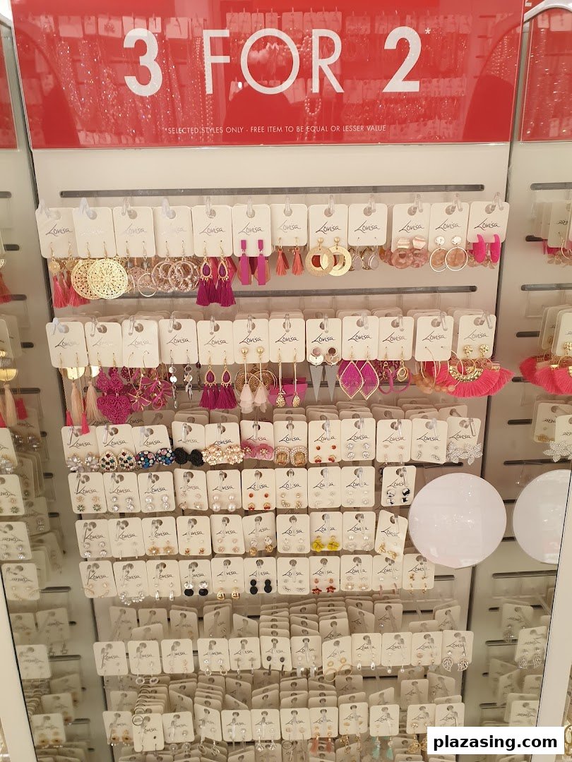 A display stand showcasing a wide variety of Lovisa earrings with a prominent '3 FOR 2' promotion sign.