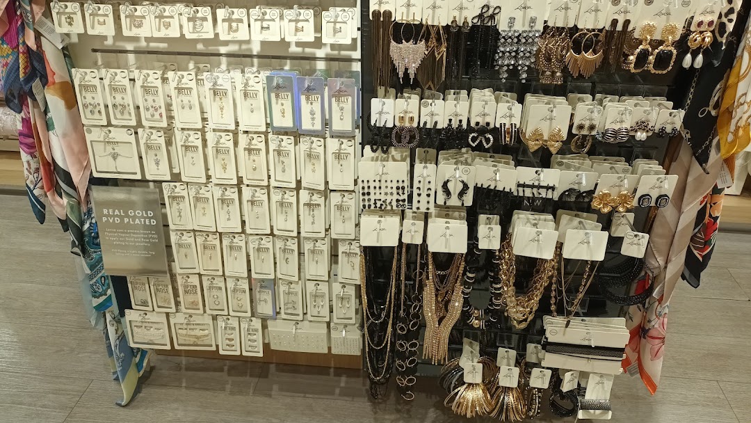 A vibrant display of diverse fashion jewelry, including earrings, necklaces, and body piercings, at Lovisa.