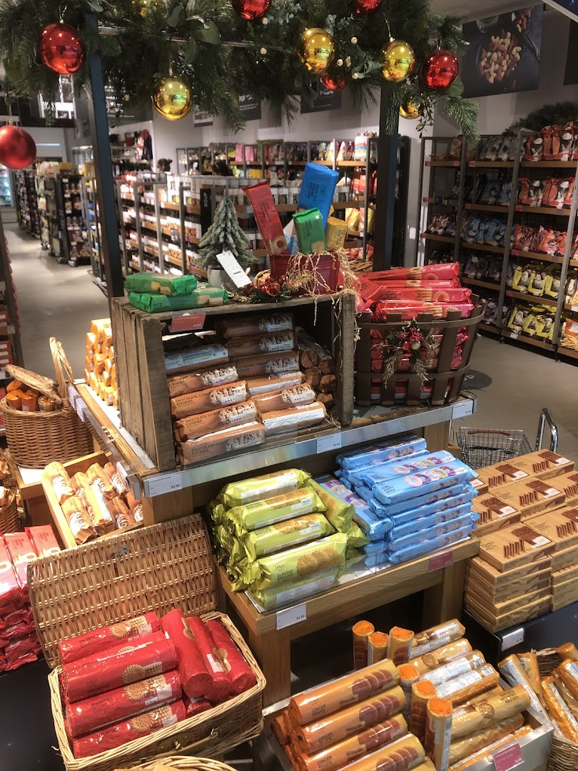 An interior view of Marks & Spencer's food hall, featuring festive decorations and a wide array of packaged food products.