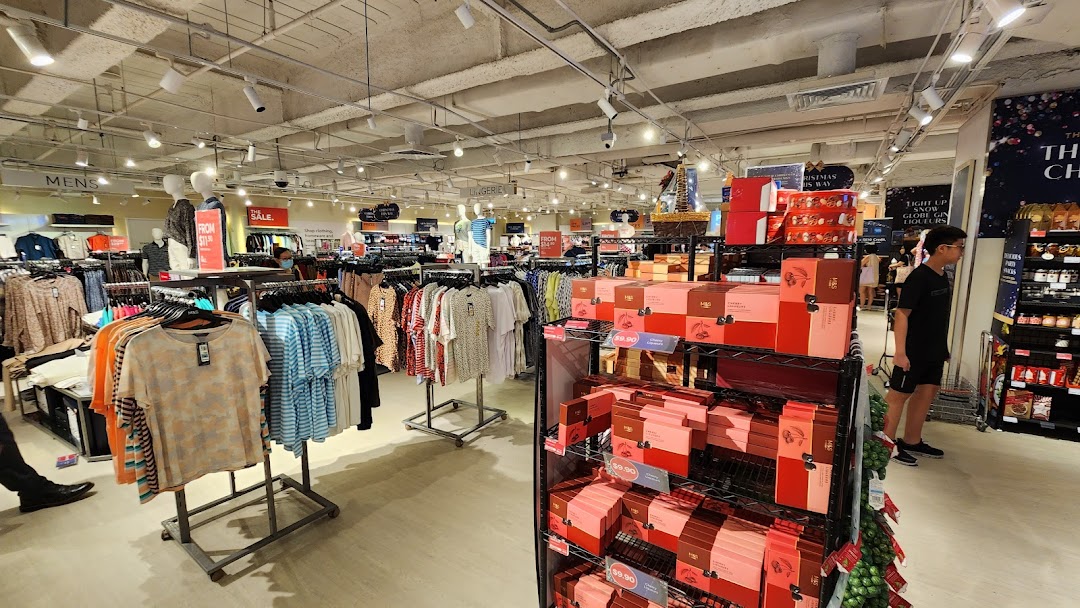 Interior view of Marks & Spencer, showcasing clothing racks, sale items, and festive food/gift displays.