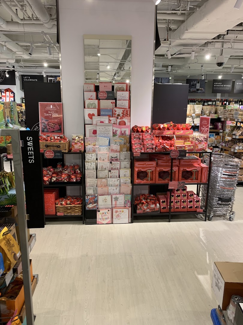 A Marks & Spencer store aisle featuring a festive display of Valentine's Day chocolates, sweets, and greeting cards.
