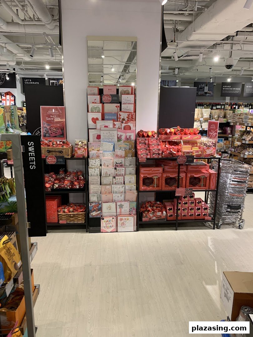 A Marks & Spencer store aisle featuring a festive display of Valentine's Day chocolates, sweets, and greeting cards.