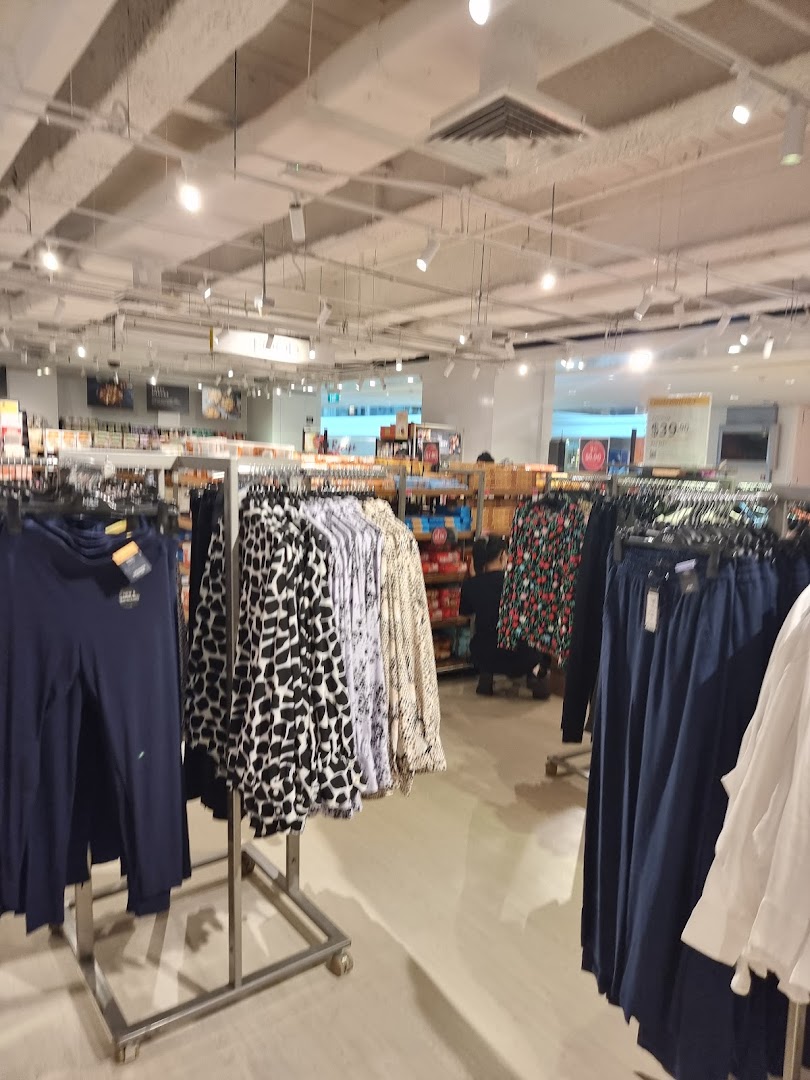 An interior view of Marks & Spencer, showcasing various clothing items on display racks.