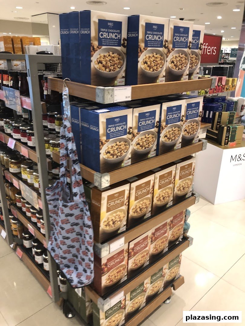 A vibrant display of Marks & Spencer Triple Chocolate Crunch cereals and other M&S food items in a retail store.