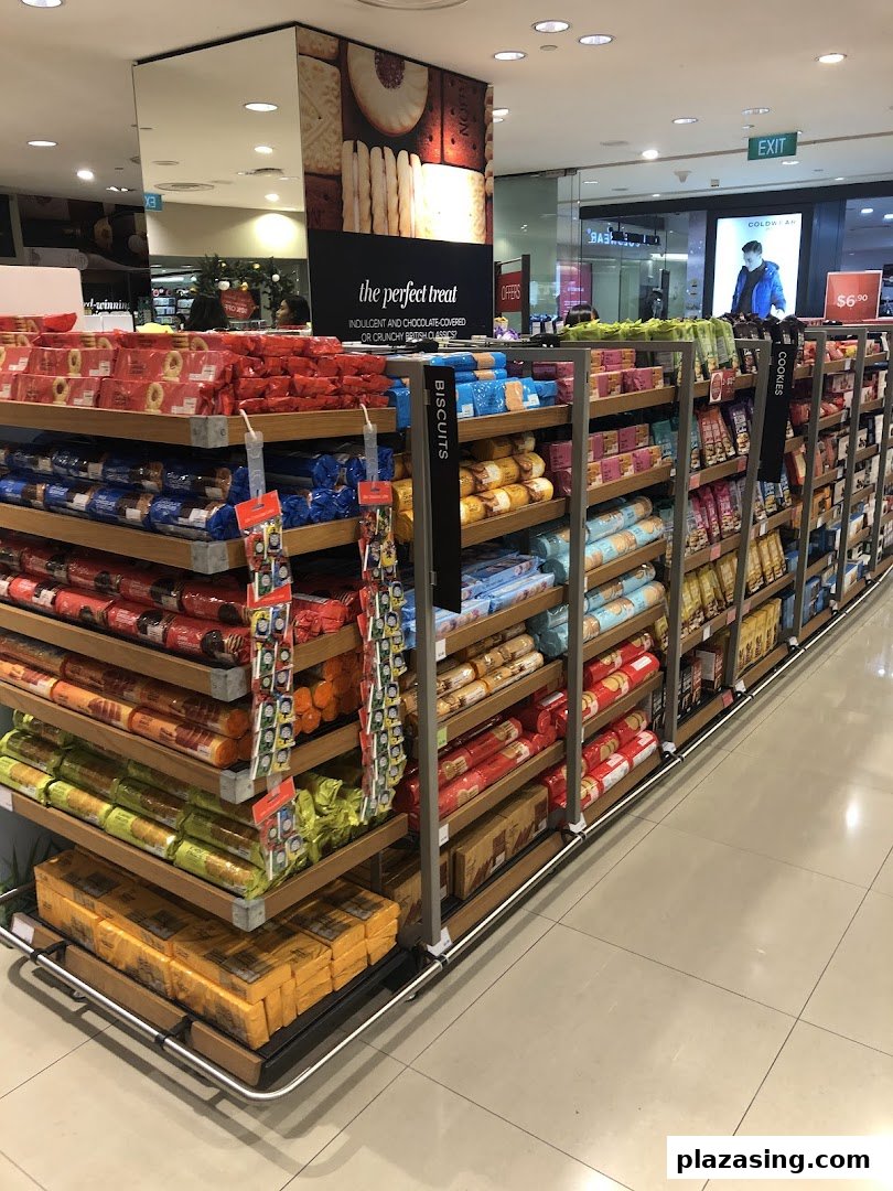 An aisle in Marks & Spencer showcasing a wide selection of biscuits and cookies, including British classics.