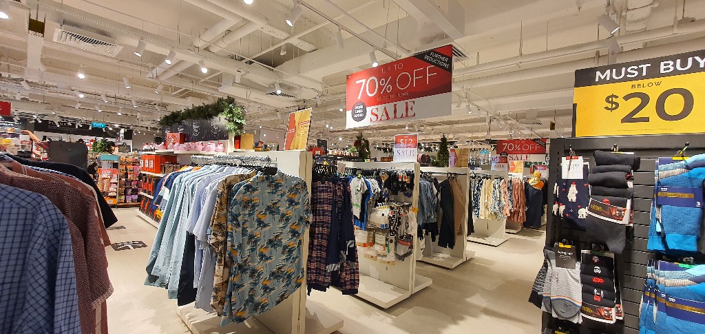 Interior view of Marks & Spencer, showcasing clothing racks and prominent sale signage.