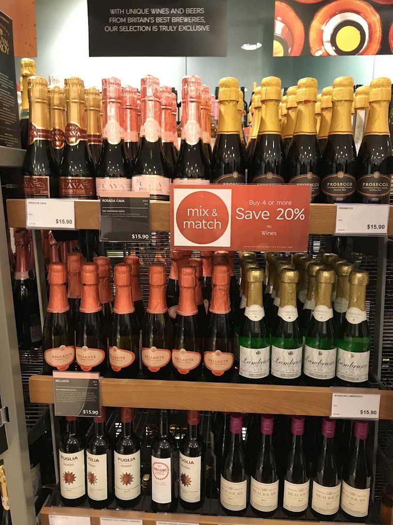 Shelves displaying various sparkling wine and wine bottles with prices and a 'mix & match' offer.