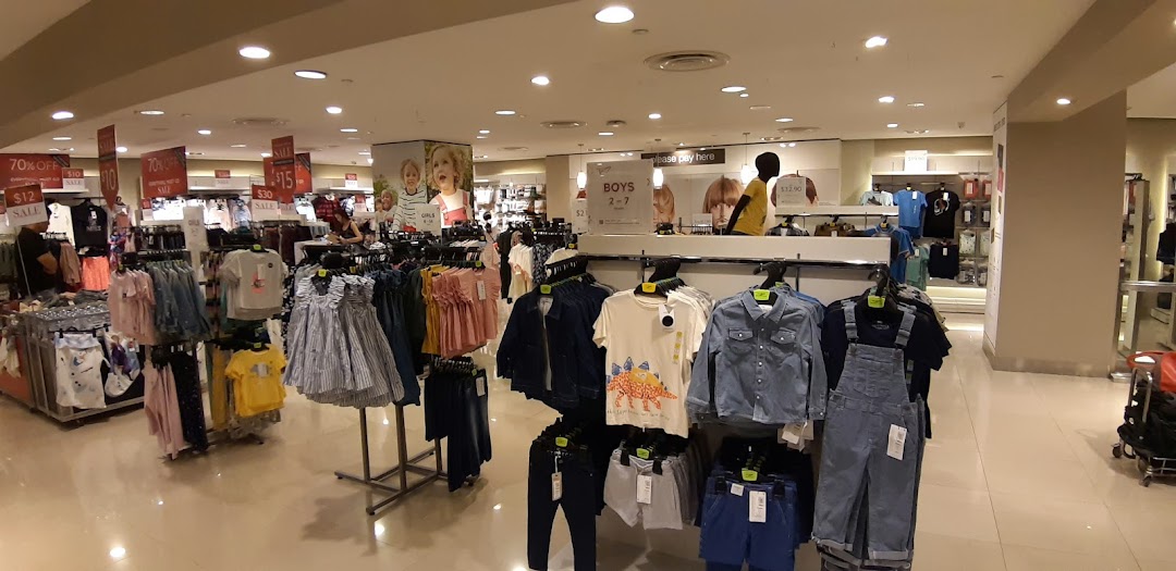Interior view of a Marks & Spencer store featuring children's clothing racks and sale signs.