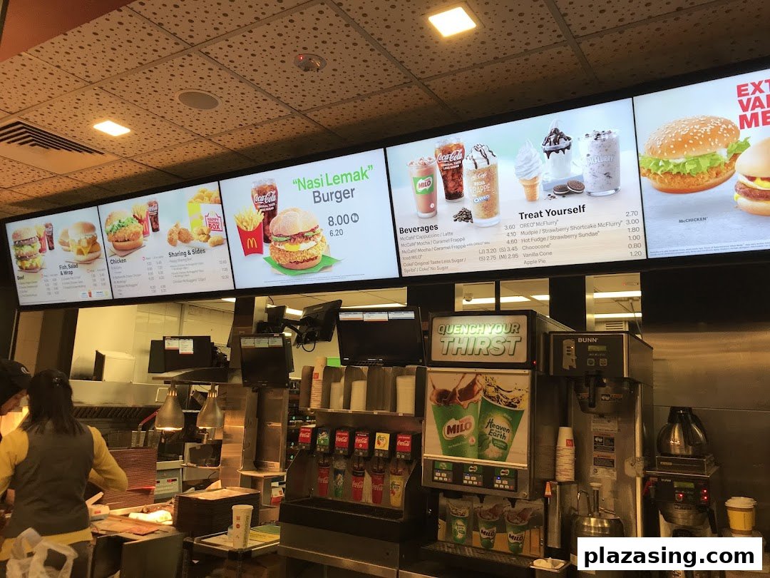 Digital menu boards at McDonald's, showcasing a variety of burgers, beverages, and desserts.