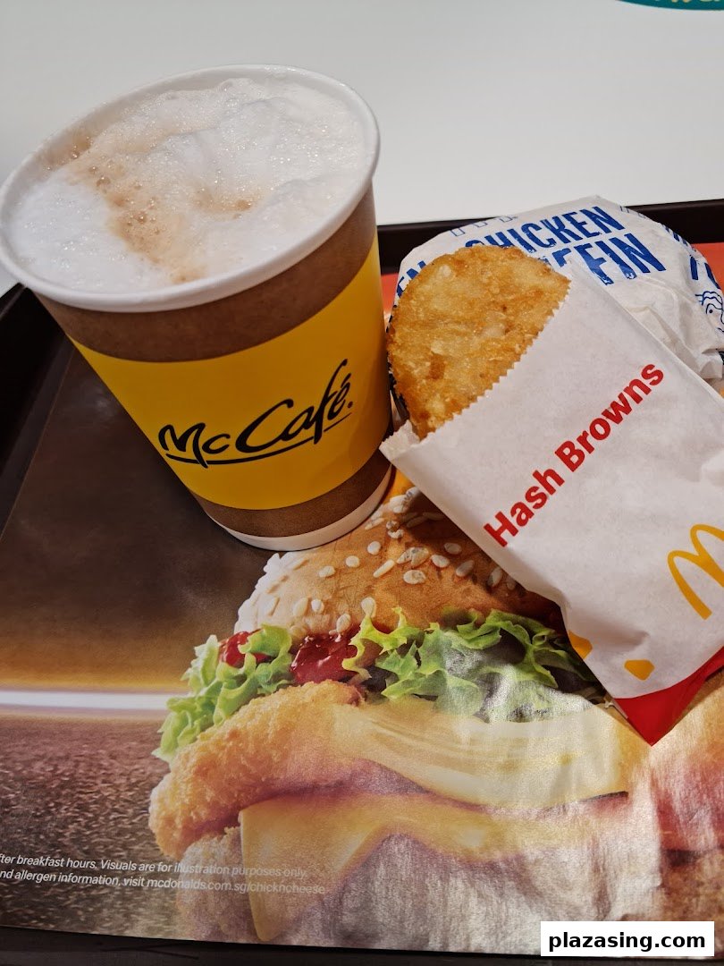 A McCafe coffee, hash brown, and burger wrapper on a McDonald's tray liner.