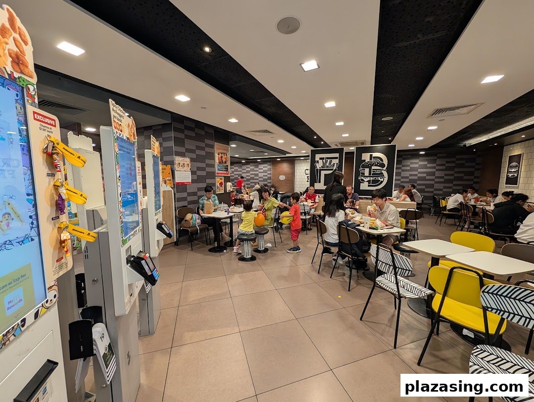 Customers enjoy meals in the spacious, modern dining area of McDonald's, featuring self-order kiosks.