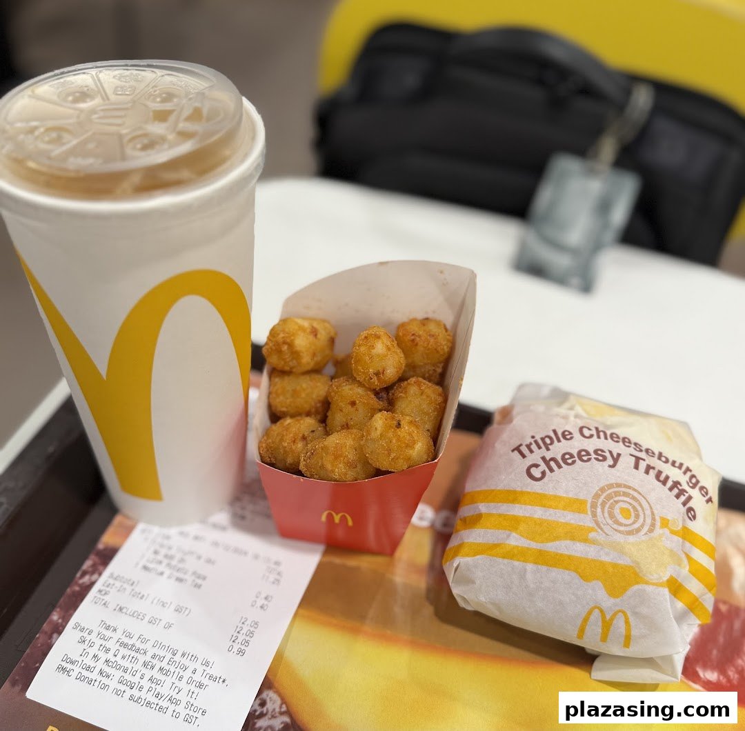 A McDonald's meal featuring a Triple Cheeseburger Cheesy Truffle, tater tots, and a drink.