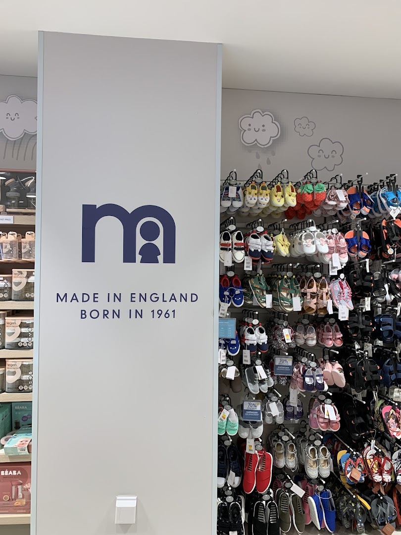 An interior shot of Mothercare, featuring a brand sign and a colorful display of children's footwear.