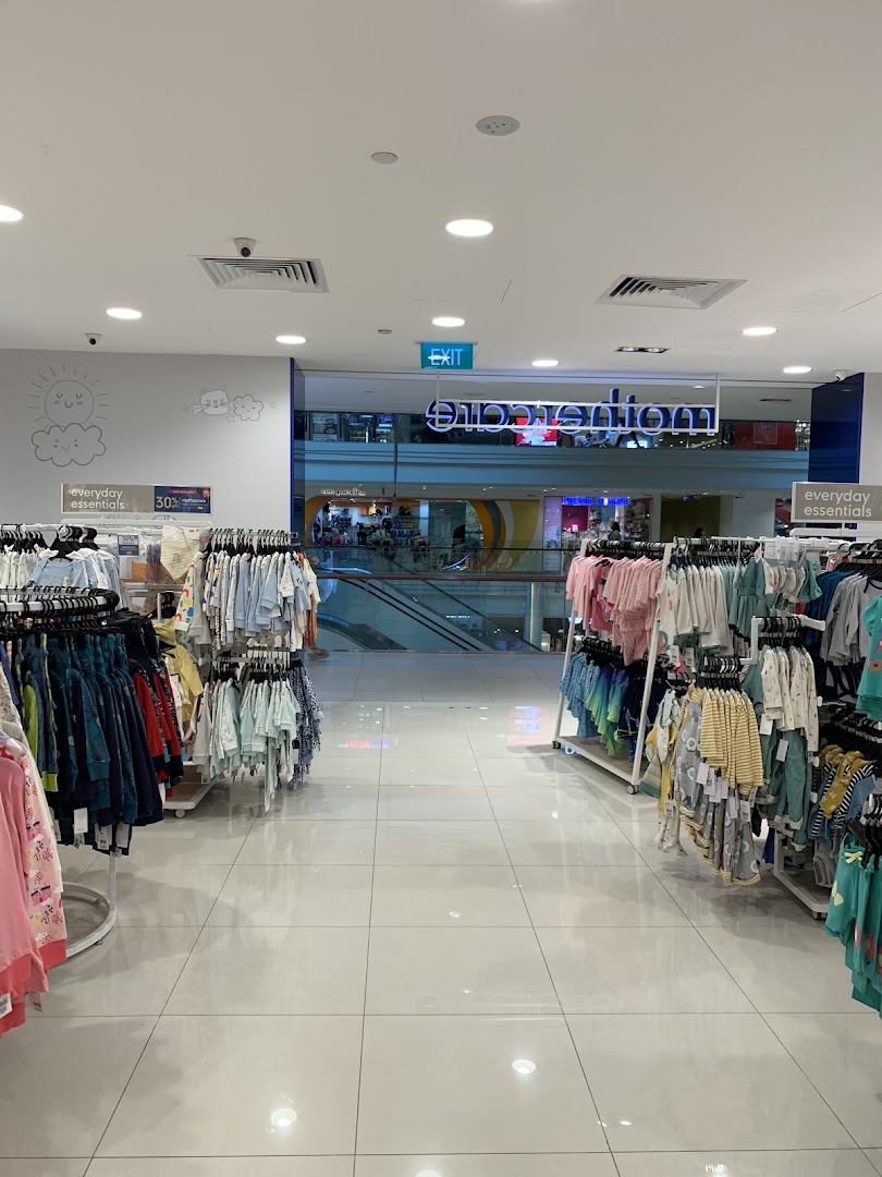 Interior view of Mothercare, showcasing baby and children's clothing racks leading to the mall entrance.