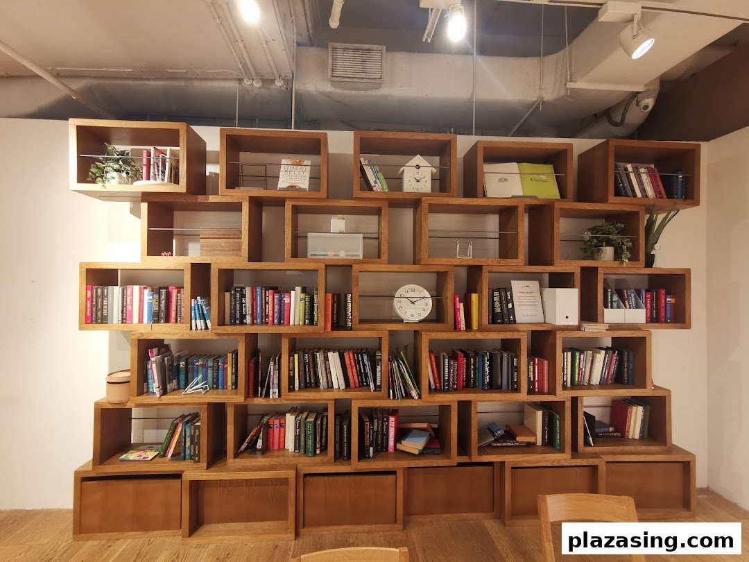 A large, modern wooden bookshelf filled with books and decorative items, showcasing MUJI's minimalist aesthetic.