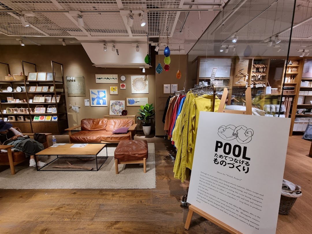 A cozy interior view of MUJI, showcasing furniture, home goods, and apparel displays.