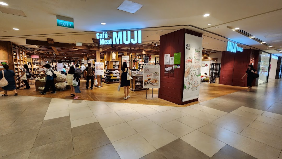 The entrance of MUJI Plaza Singapura, showcasing its lifestyle products and 'Cafe & Meal MUJI' section.