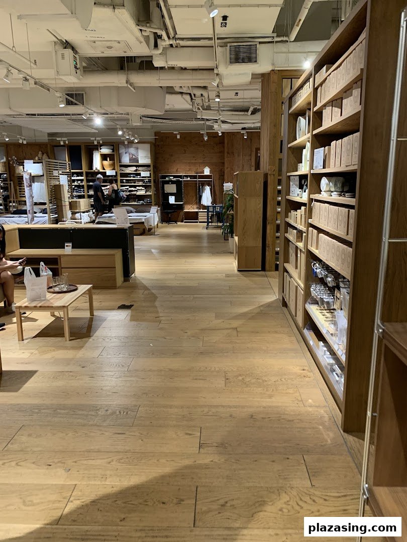Interior view of MUJI Plaza Singapura, showcasing wooden shelves filled with products and a minimalist design.