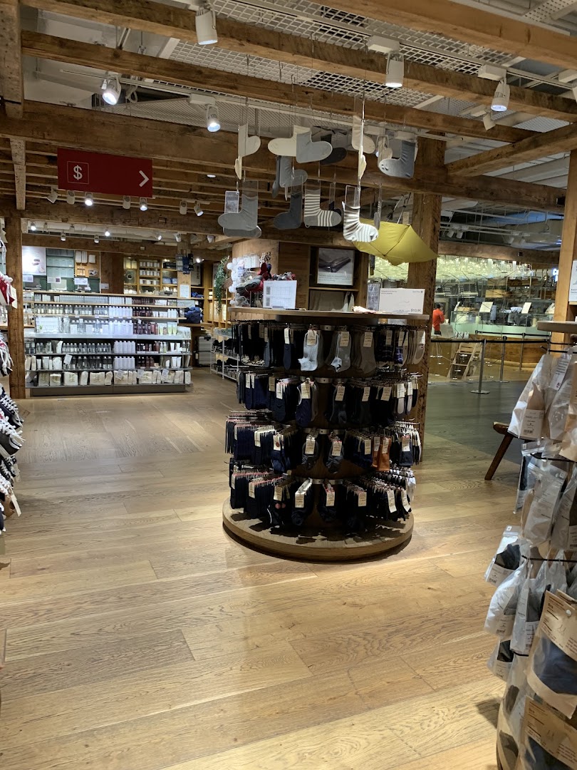 Interior of MUJI showcasing minimalist products like socks and toiletries in a warm, wooden setting.