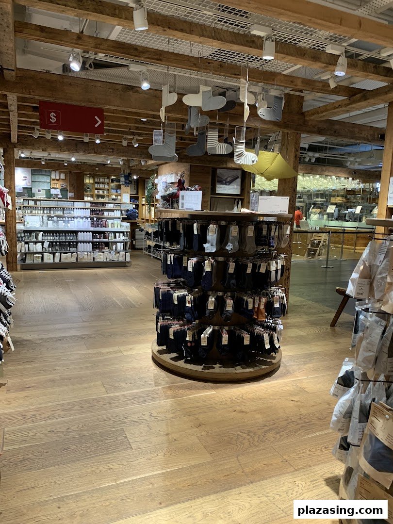 Interior of MUJI showcasing minimalist products like socks and toiletries in a warm, wooden setting.