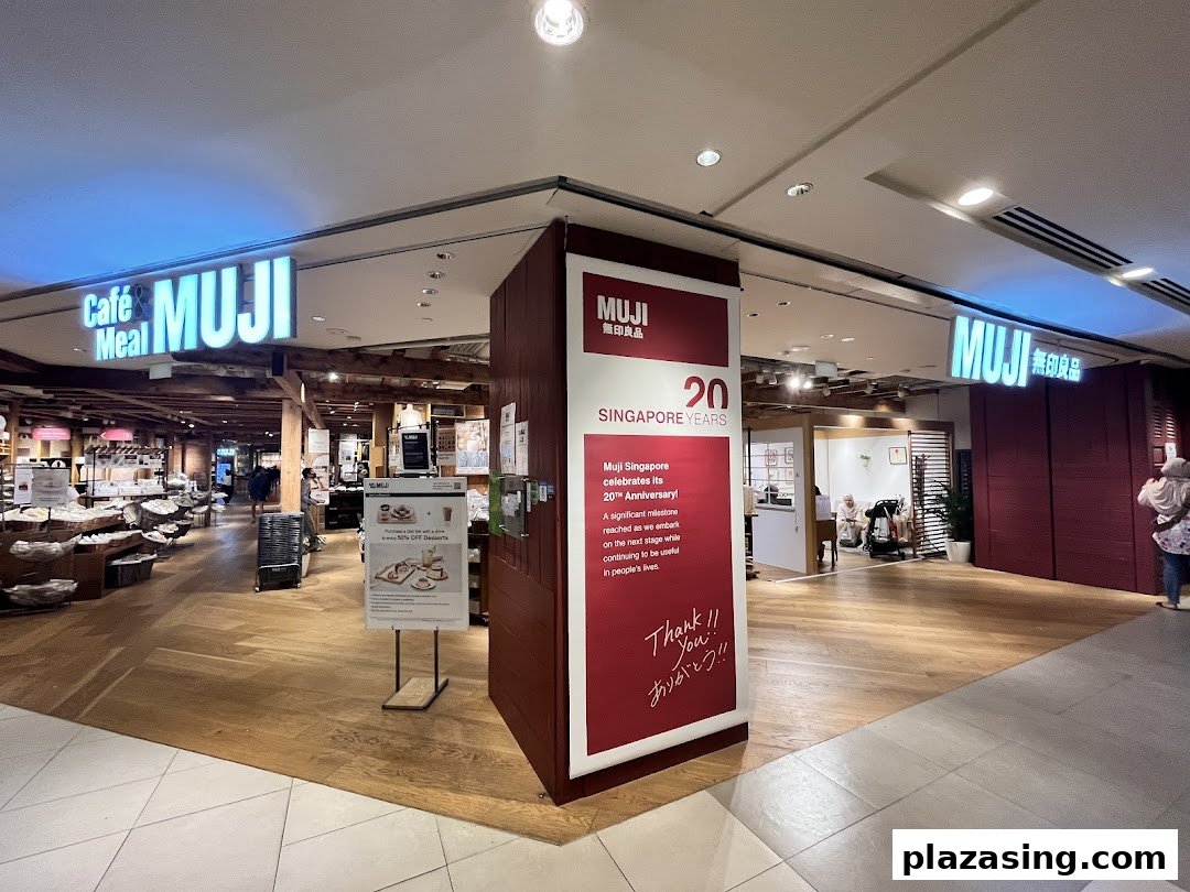 The entrance of MUJI Plaza Singapura, featuring its Cafe & Meal section and a 20th-anniversary celebration banner.