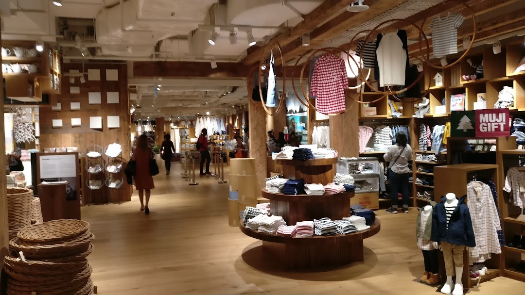 Interior view of MUJI Plaza Singapura, showcasing clothing, home goods, and customers browsing products.