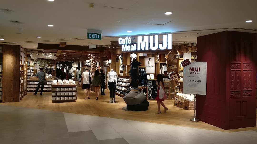 The entrance of MUJI Plaza Singapura, showcasing its minimalist interior and diverse product range, with customers browsing.