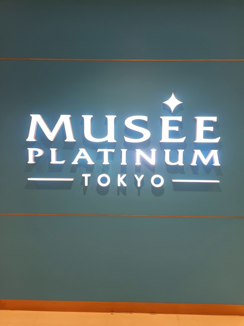 Illuminated sign for Musee Platinum Tokyo, a beauty salon, on a teal wall.