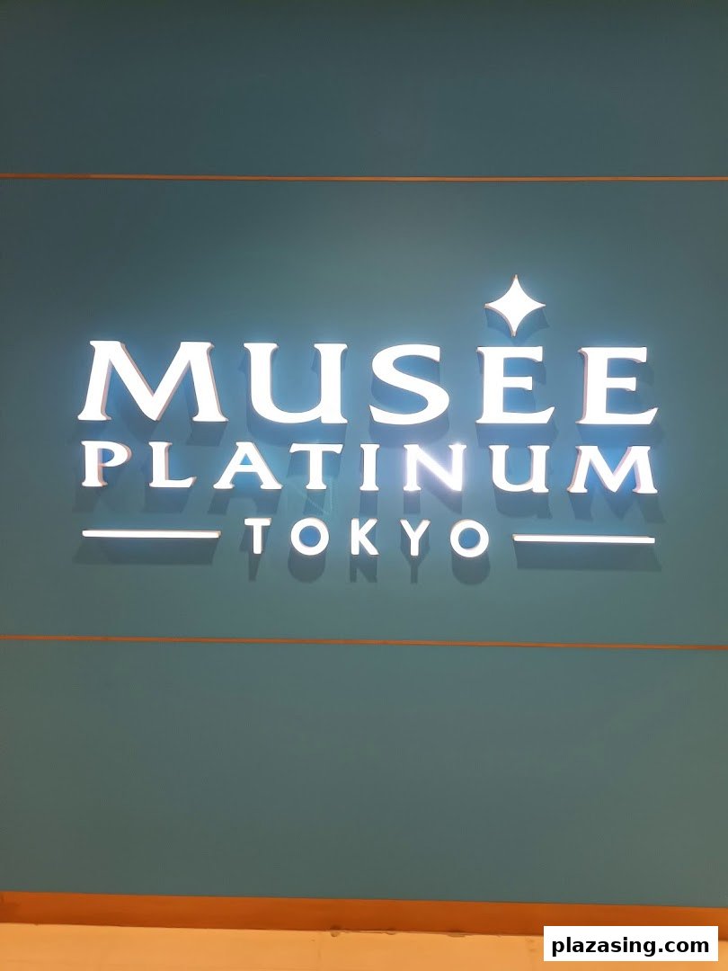 Illuminated sign for Musee Platinum Tokyo, a beauty salon, on a teal wall.