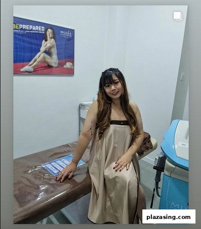 A woman in a treatment room at Musee Platinum Tokyo, featuring a treatment bed and a promotional poster.