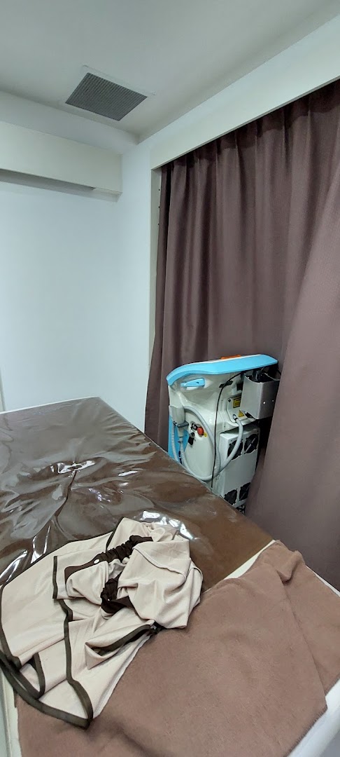 A clean, private treatment room with a bed and advanced beauty equipment at Musee Platinum Tokyo.