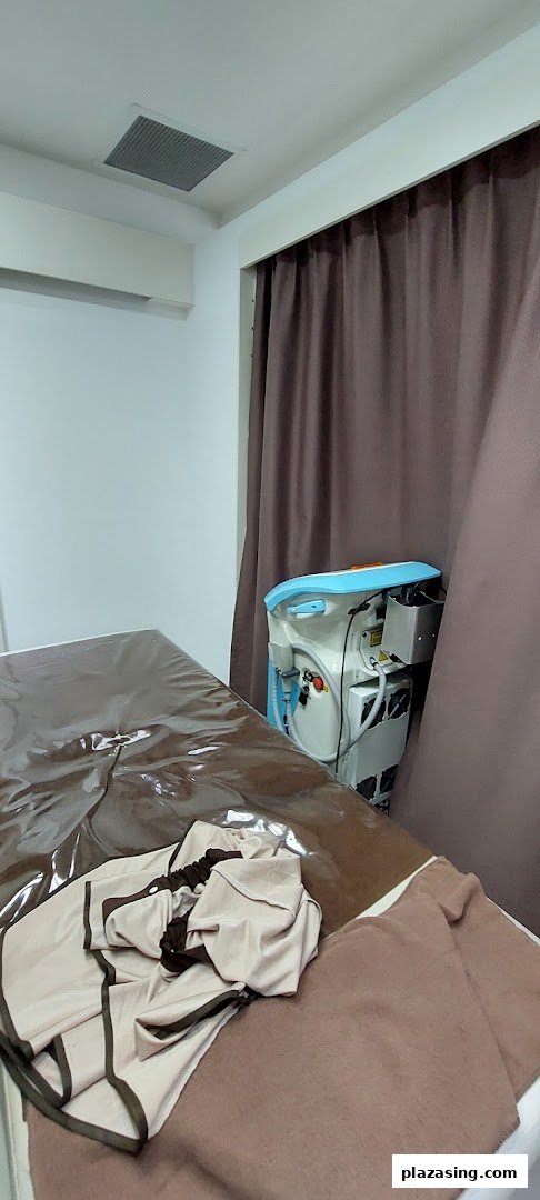 A clean, private treatment room with a bed and advanced beauty equipment at Musee Platinum Tokyo.