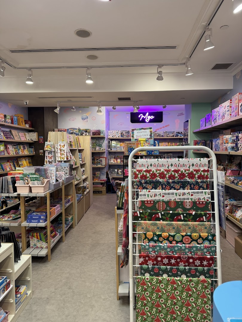 An interior view of My Greatest Child Plaza Singapura, showcasing shelves filled with books, toys, and festive wrapping paper.