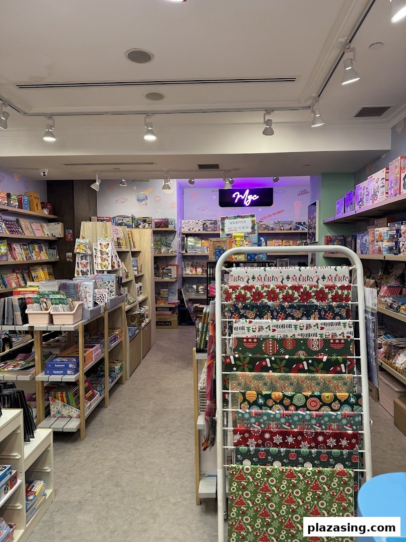 An interior view of My Greatest Child Plaza Singapura, showcasing shelves filled with books, toys, and festive wrapping paper.