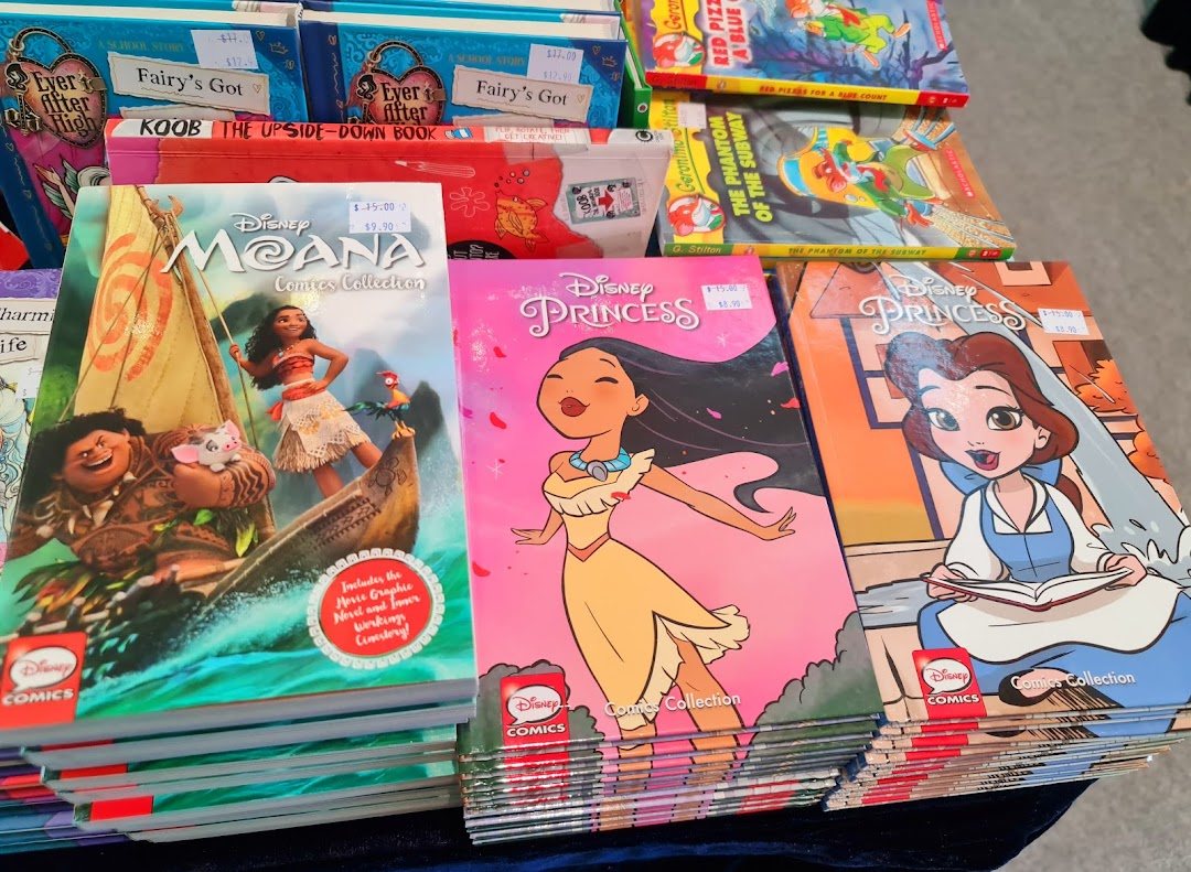 Close-up of Disney and children's comic books and novels on display.