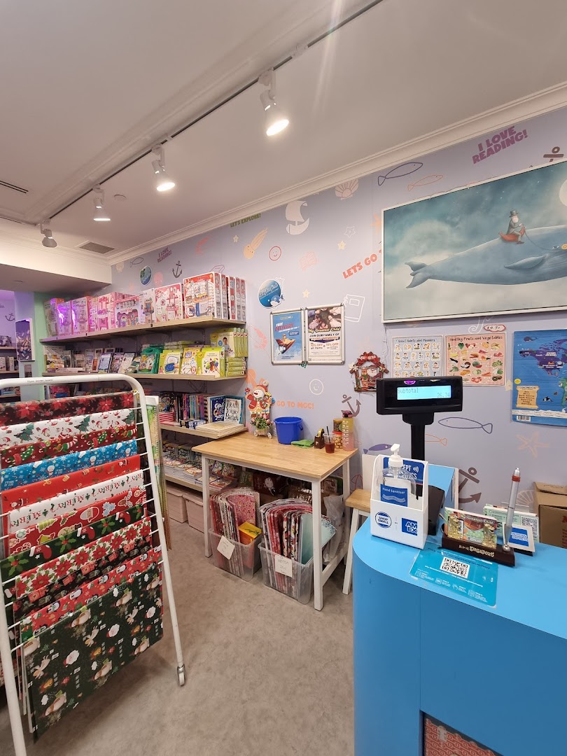 Interior view of My Greatest Child Plaza Singapura, featuring books, educational toys, gift wrap, and a checkout counter.
