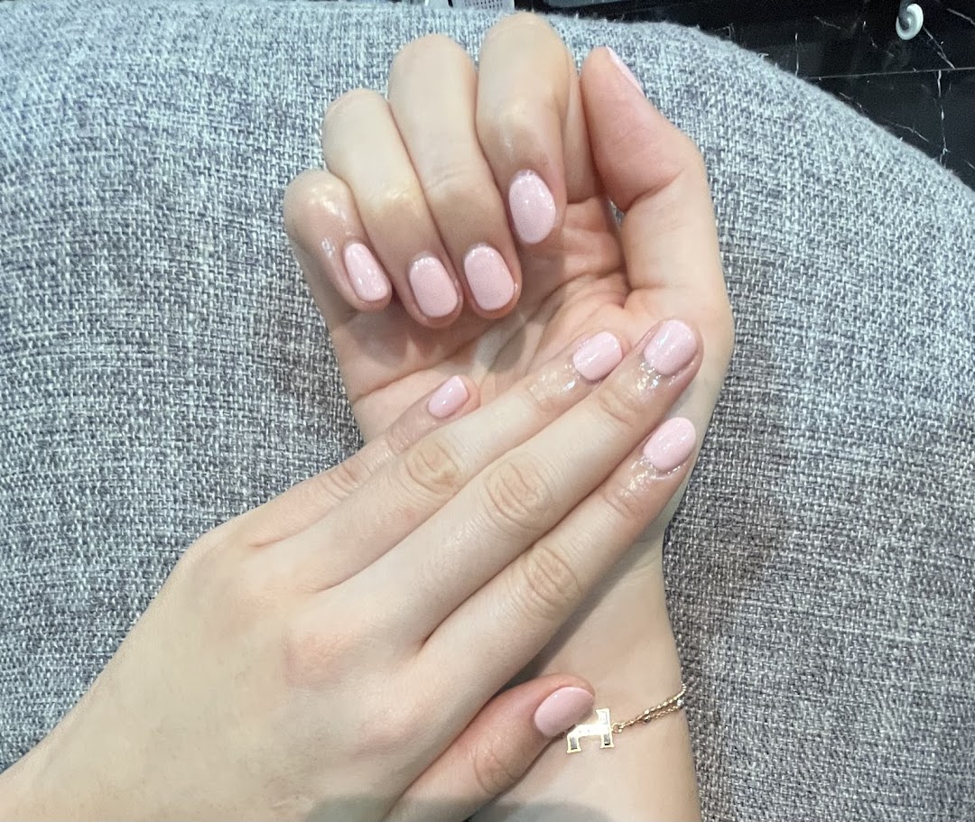 Close-up of hands showcasing a fresh, light pink manicure from N20 Nail Spa.