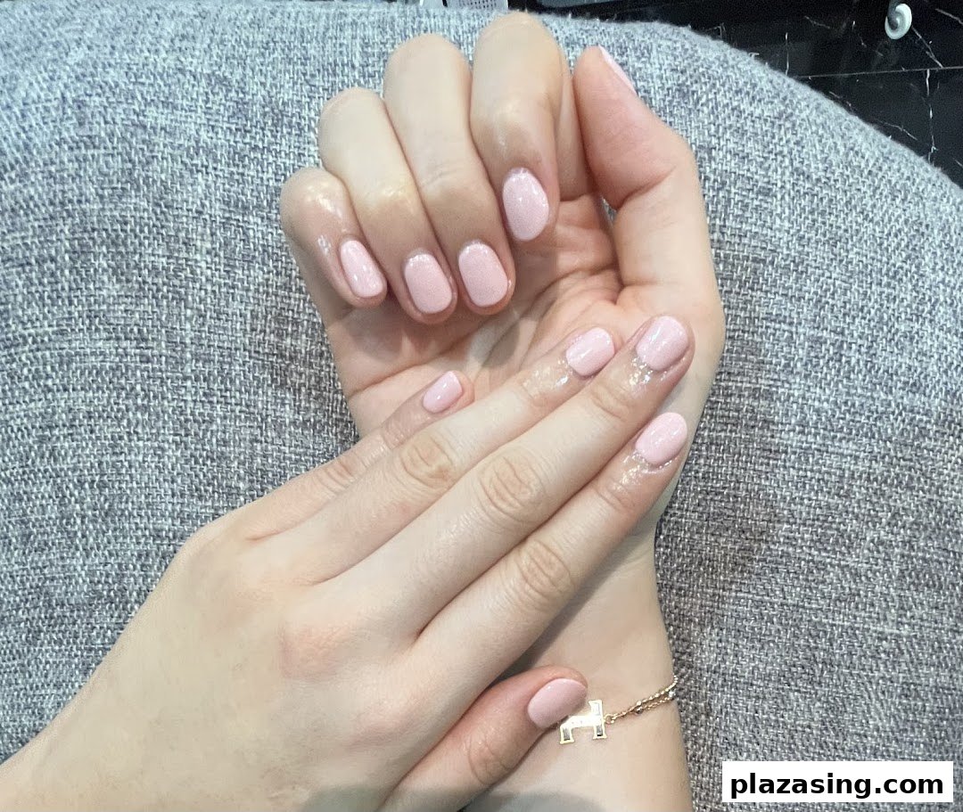 Close-up of hands showcasing a fresh, light pink manicure from N20 Nail Spa.
