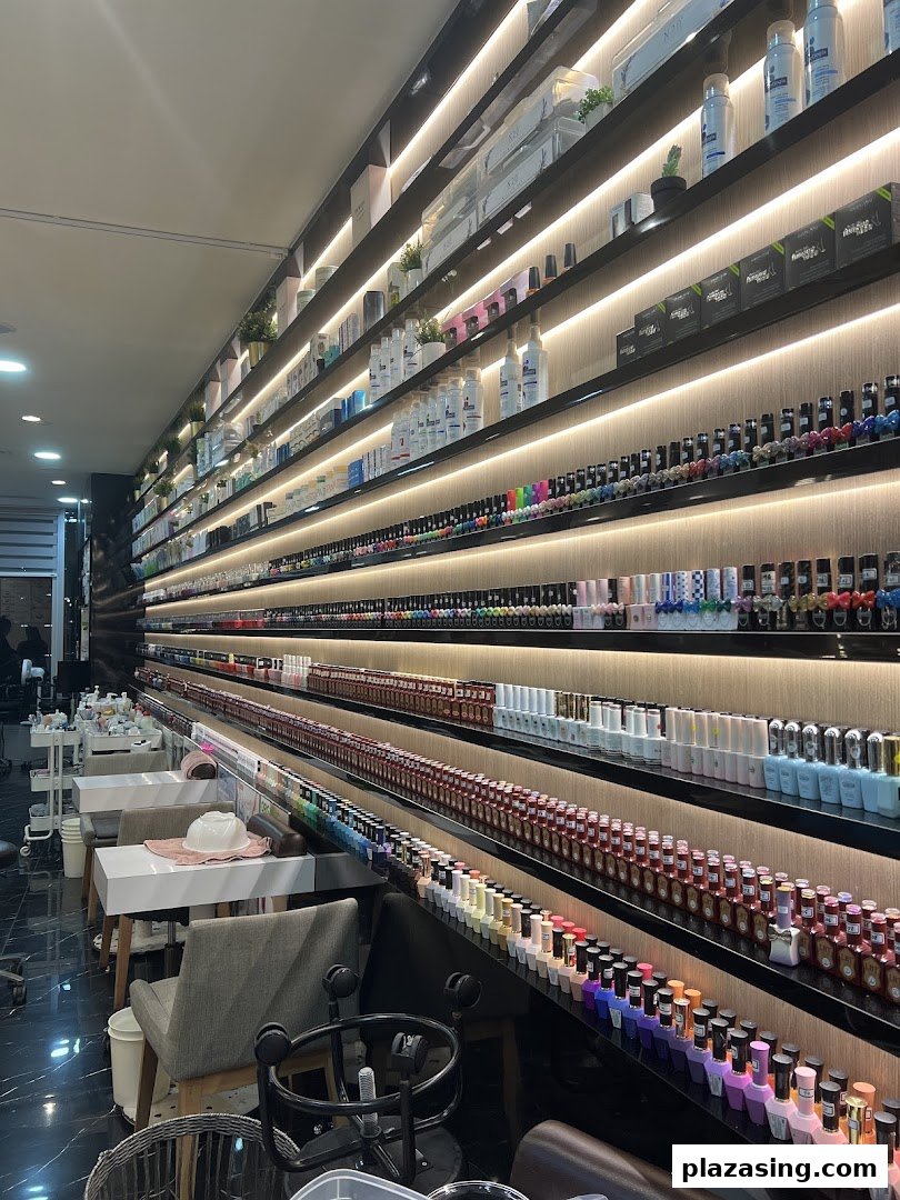 A vibrant display of nail polish colors and beauty products lining the illuminated walls of a modern nail spa.