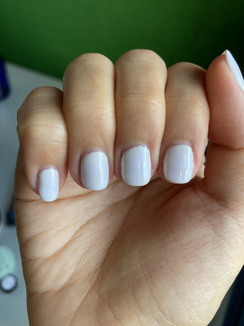 A close-up of a hand showcasing freshly manicured nails with a light blue polish.