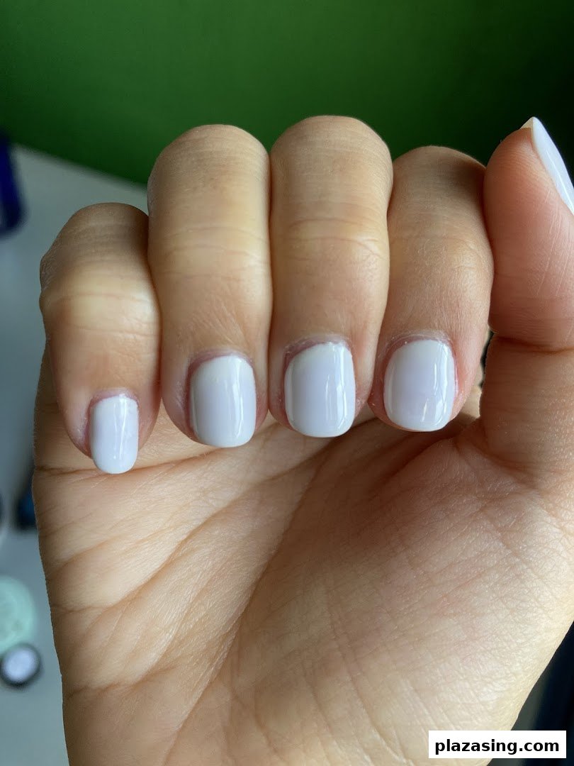 A close-up of a hand showcasing freshly manicured nails with a light blue polish.