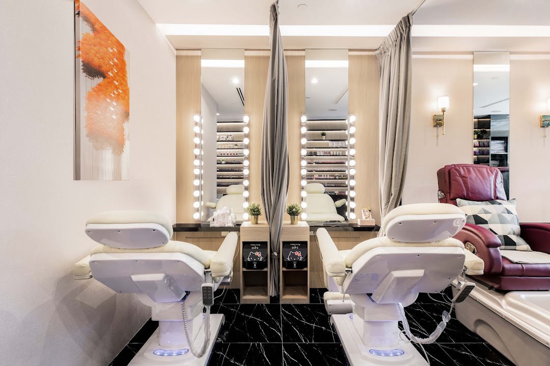 Bright and modern nail spa interior with comfortable treatment chairs, vanity mirrors, and nail polish displays.