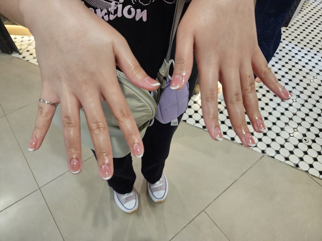 Close-up of hands showcasing a fresh French manicure with clear polish.