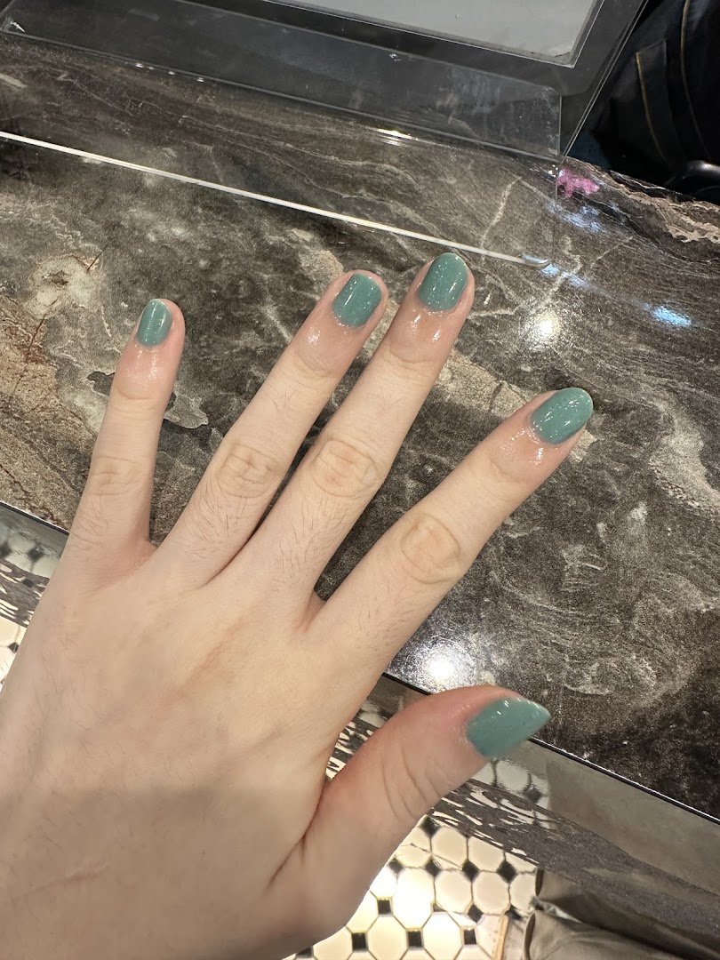 A hand showcasing freshly painted nails in a stylish teal shade at N20 Nail Spa.