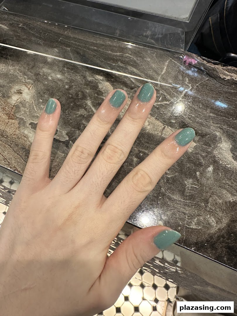 A hand showcasing freshly painted nails in a stylish teal shade at N20 Nail Spa.