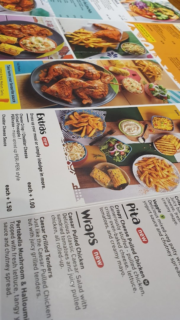 A close-up view of Nando's menu, showcasing PERi-PERi chicken dishes, wraps, pitas, and sides.